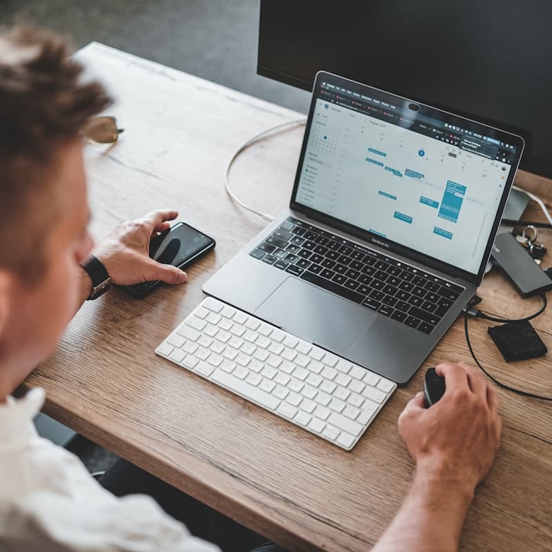 Właściciel serwisu przy laptopie planuje pracę zespołu